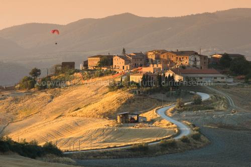 Centro abitato delle crete senesi con parapendio