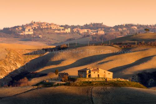 Paesaggio invernale delle crete senesi con casolare, nei dintorni delle Terme di Rapolano