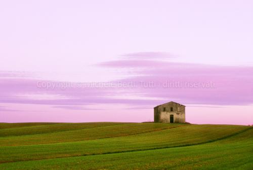 Tramonto con cielo viola e vecchio edificio rurale in Valdichiana