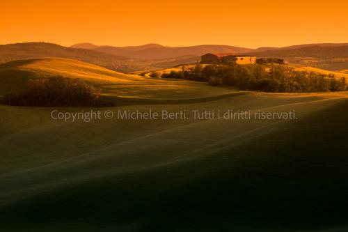 Tramonto nelle crete senesi con casolare
